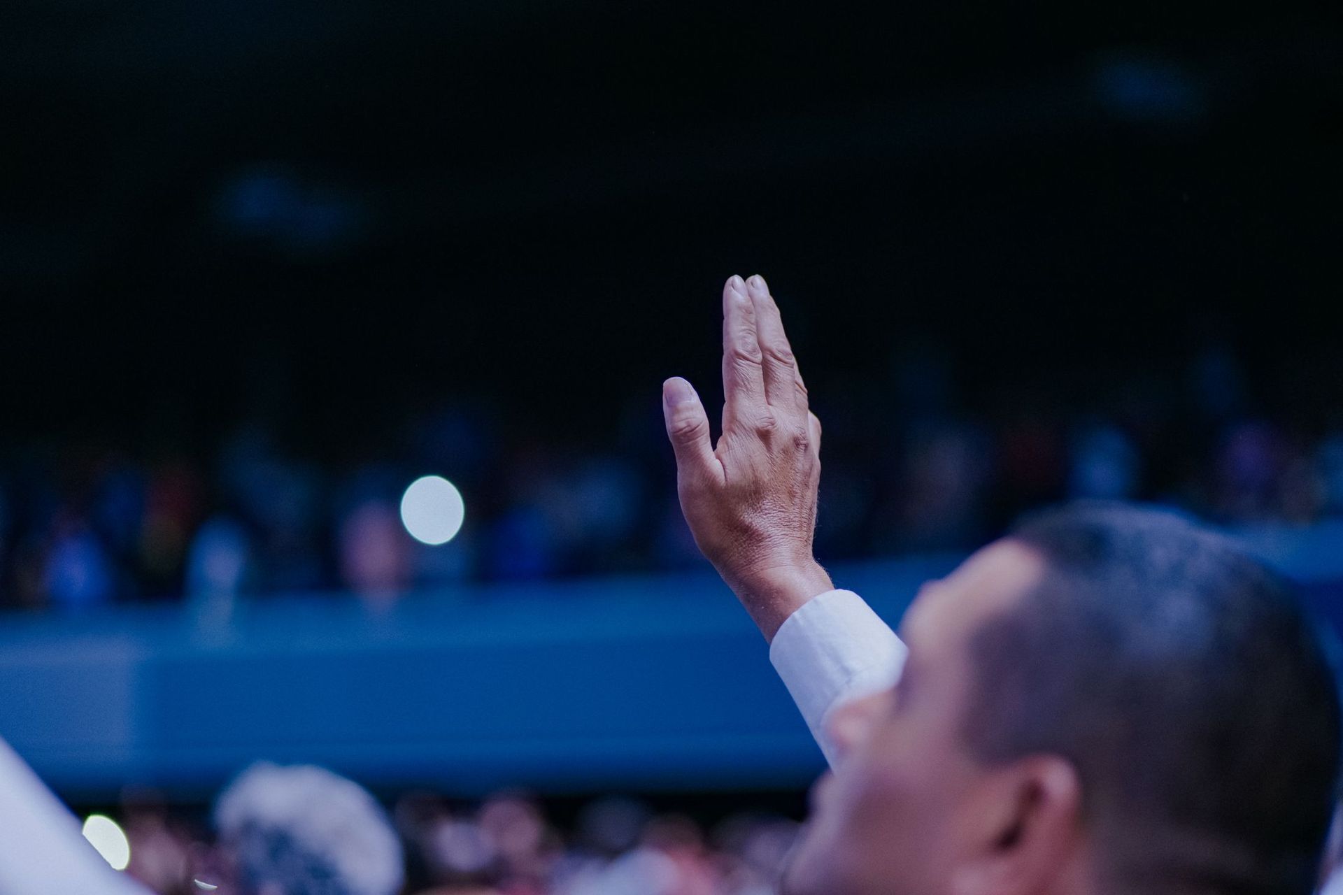 A raised hand in an audience