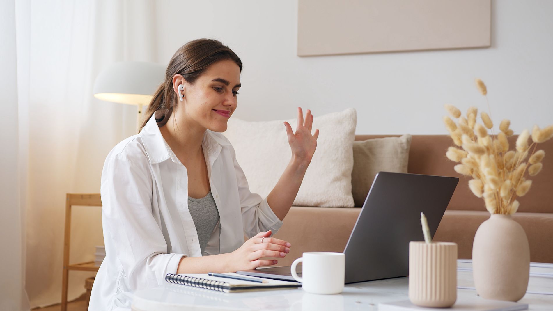A young woman smiling on a video call on her laptop